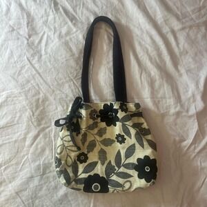 Black and cream floral print bag with magnetic closure and adjustable straps